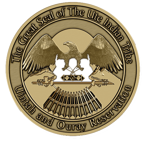 A gold colored seal with an eagle and some guns.