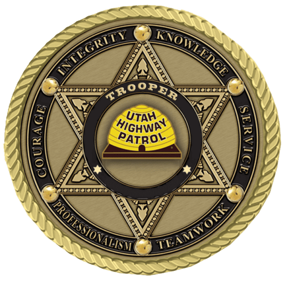 A gold colored badge with the words " trooper utah highway patrol."